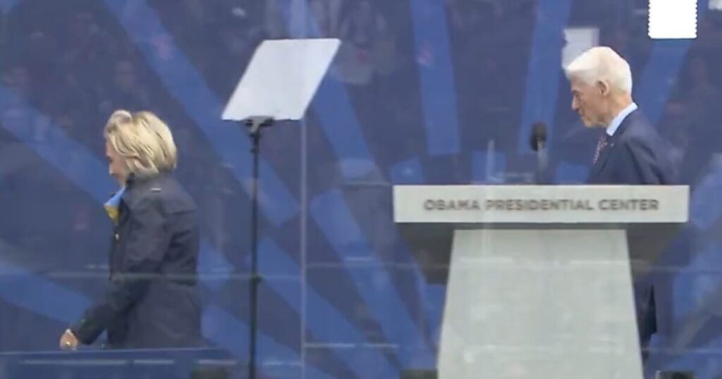 Is Hillary Hiding Something Again? Hillary Clinton Bundles Up in Warm June Weather at Obama Library Opening Ceremony – What is that Back Bulge? (VIDEO)